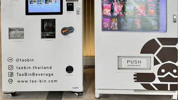 Two vending machines, one with a digital screen and the other displaying snacks.