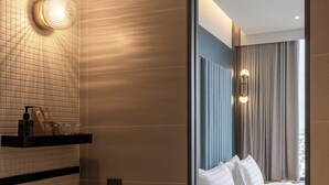 A modern bathroom with a large mirror, a white sink, and a towel rack. - The Quarter Ratchayothin by UHG (Bangkok)