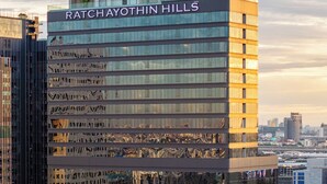A modern hotel building named Ratchayothin Hills with a glass facade and multiple floors. - The Quarter Ratchayothin by UHG (Bangkok)