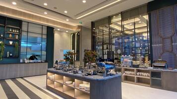 A modern hotel lobby with a central reception desk, glass display cases, and a clean, contemporary design.