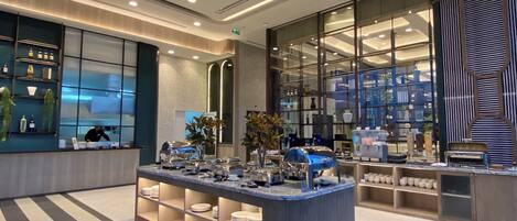 A modern hotel lobby with a central reception desk, glass display cases, and a clean, contemporary design.