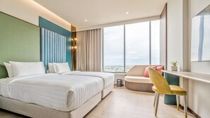 Une chambre d’hôtel moderne avec un grand lit, un bureau et une vue sur la ville.