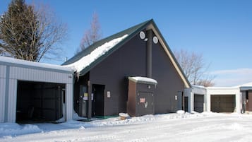 A building with multiple garage doors and a snow-covered roof.