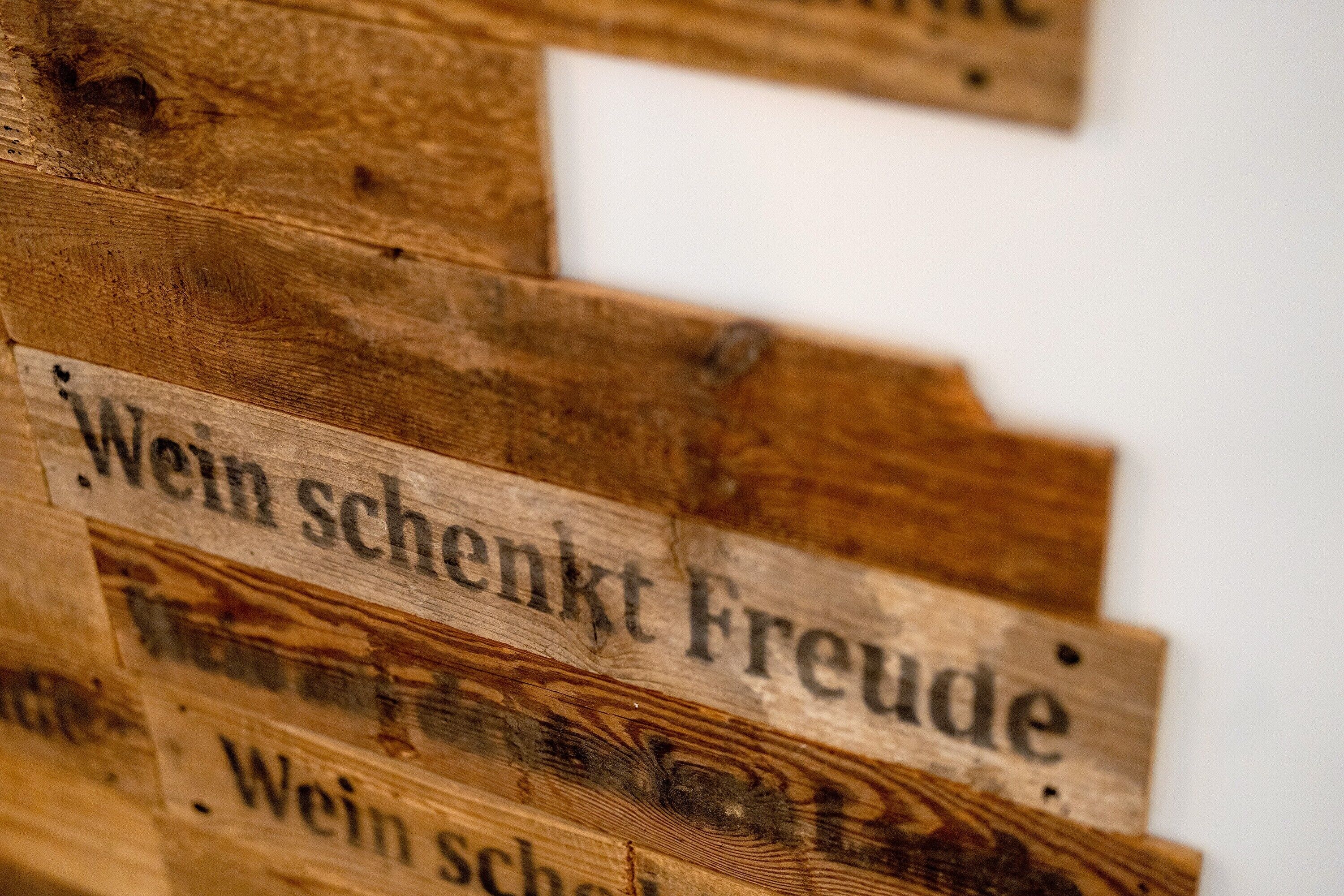 A close-up of wooden panels with text, likely part of a sign or decoration.