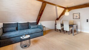 Une pièce de style loft avec un canapé, une table à manger et des chaises.