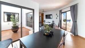 Ein modernes Interieur mit Essbereich, Fernseher und Blick ins Freie.