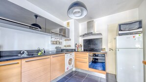 A modern kitchen with a washing machine, a microwave, and a refrigerator. - Apartment 'Bel Appartement Bordeaux Centre' with Wi-Fi and Air Conditioning (Bordeaux)