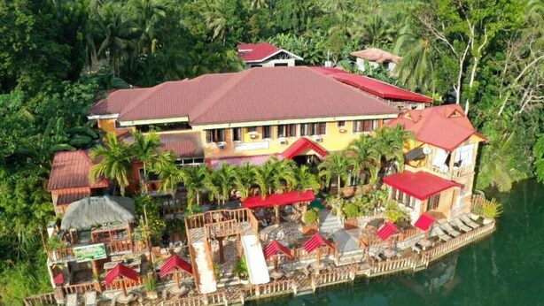 Un hôtel situé au bord de l’eau, doté de nombreux balcons, d’espaces extérieurs aménagés et d’un quai.