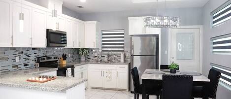 Kylskåp, mikrovågsugn, spishäll och grytor/köksredskap