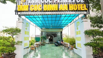 L’entrée de l’hôtel Tam Coc Binh An se distingue par une allée couverte et des plantes en pot.
