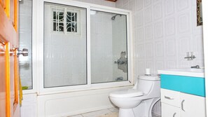 Ein Badezimmer mit Toilette, Duschkabine und Waschbecken mit Spiegel.