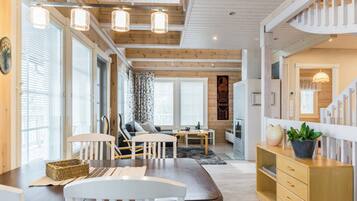 A modern interior with a dining area, seating, and a staircase.