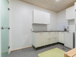 Une cuisine de taille réduite avec des meubles blancs, un plan de travail et un évier.