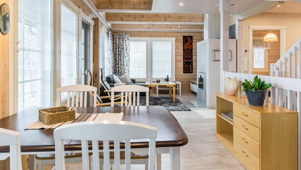 Un interior moderno con comedor, asientos y una escalera.
