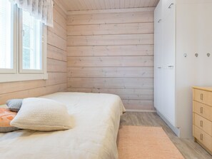 Una camera da letto con un letto, un armadio e una finestra con persiane.
