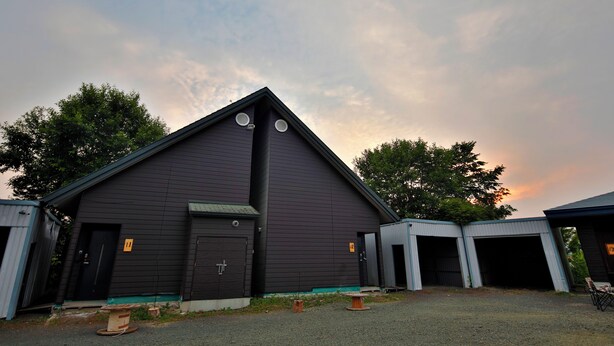 A dark-colored building with a triangular roof and two visible doors. - STARRY SKY COTTAGE 17 (Kitami)