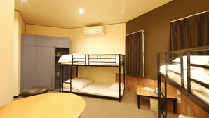 A compact hotel room with bunk beds, a desk, a chair, and a wardrobe. - STARRY SKY COTTAGE 16 (Kitami)