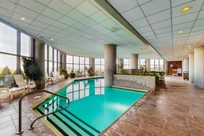Relax by the pool surrounded by lush greenery and comfortable lounge chairs.