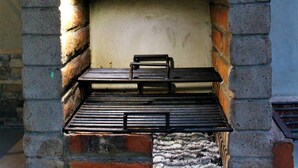 Ein Kamin aus Ziegelsteinen mit einem Metallgitter und einem kleinen Podest davor.