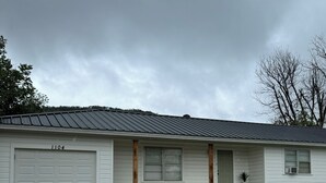 A single-story house with a garage, a front porch, and a small front yard. - Gig ‘Em Getaway (Santa Anna)