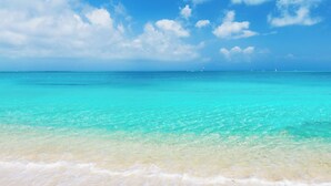 A beach with clear turquoise water and white sand.