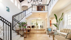A spacious living area with a staircase, a chandelier, and a view of the interior.