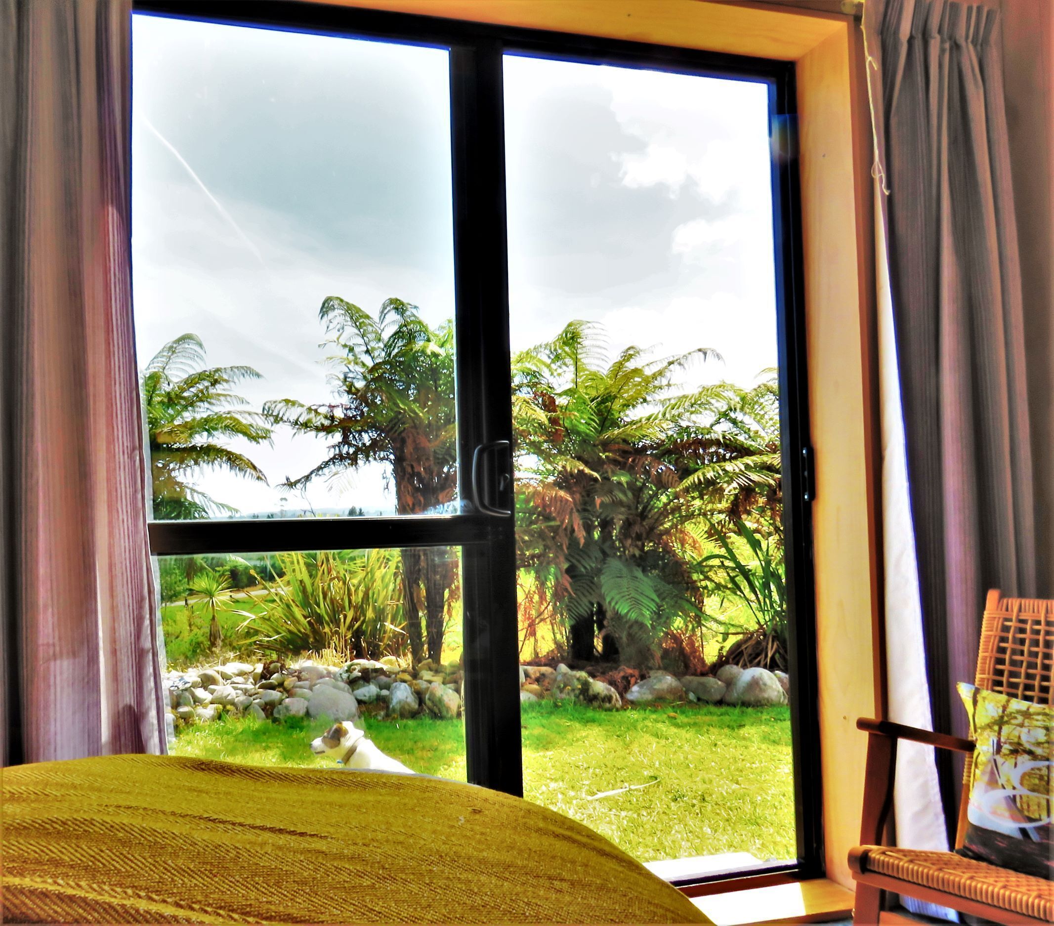 A room with a large window, a bed, and a chair.
