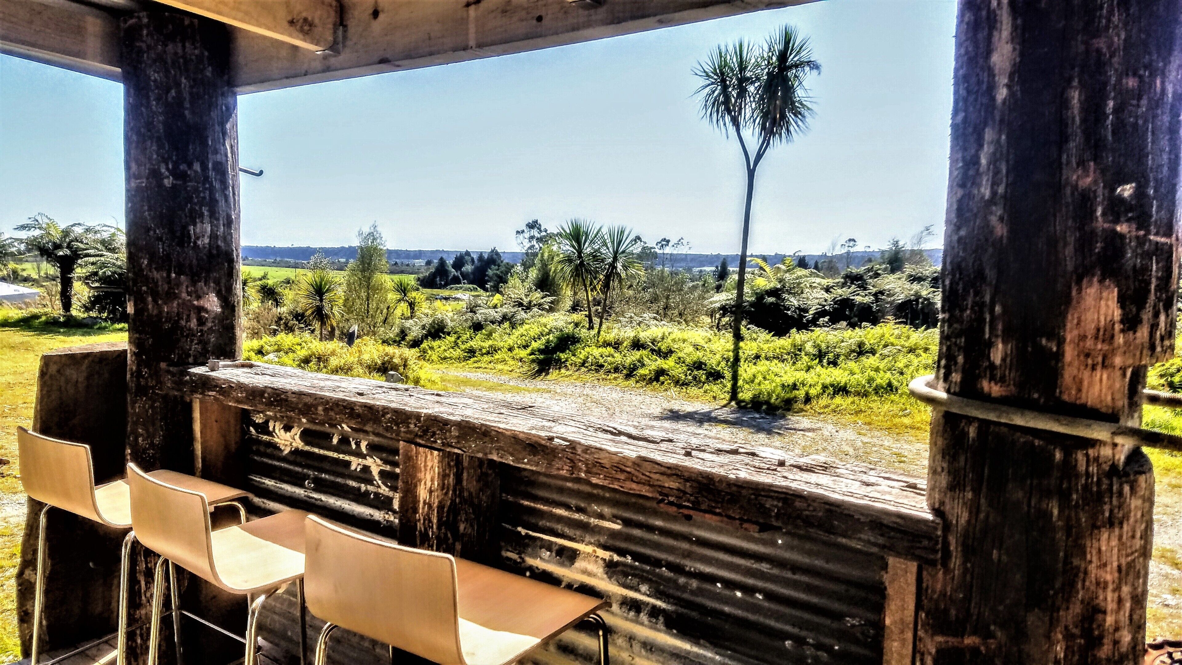 A rustic outdoor seating area with a view of a lush landscape.
