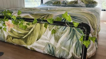 A bedroom with a bed, a window, and a plant rail.