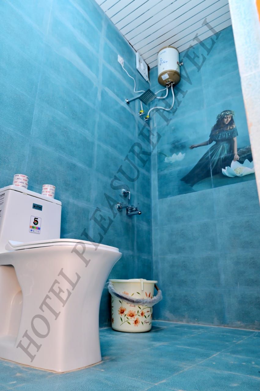 Ein Badezimmer mit Toilette, Warmwasserbereiter und Dusche.