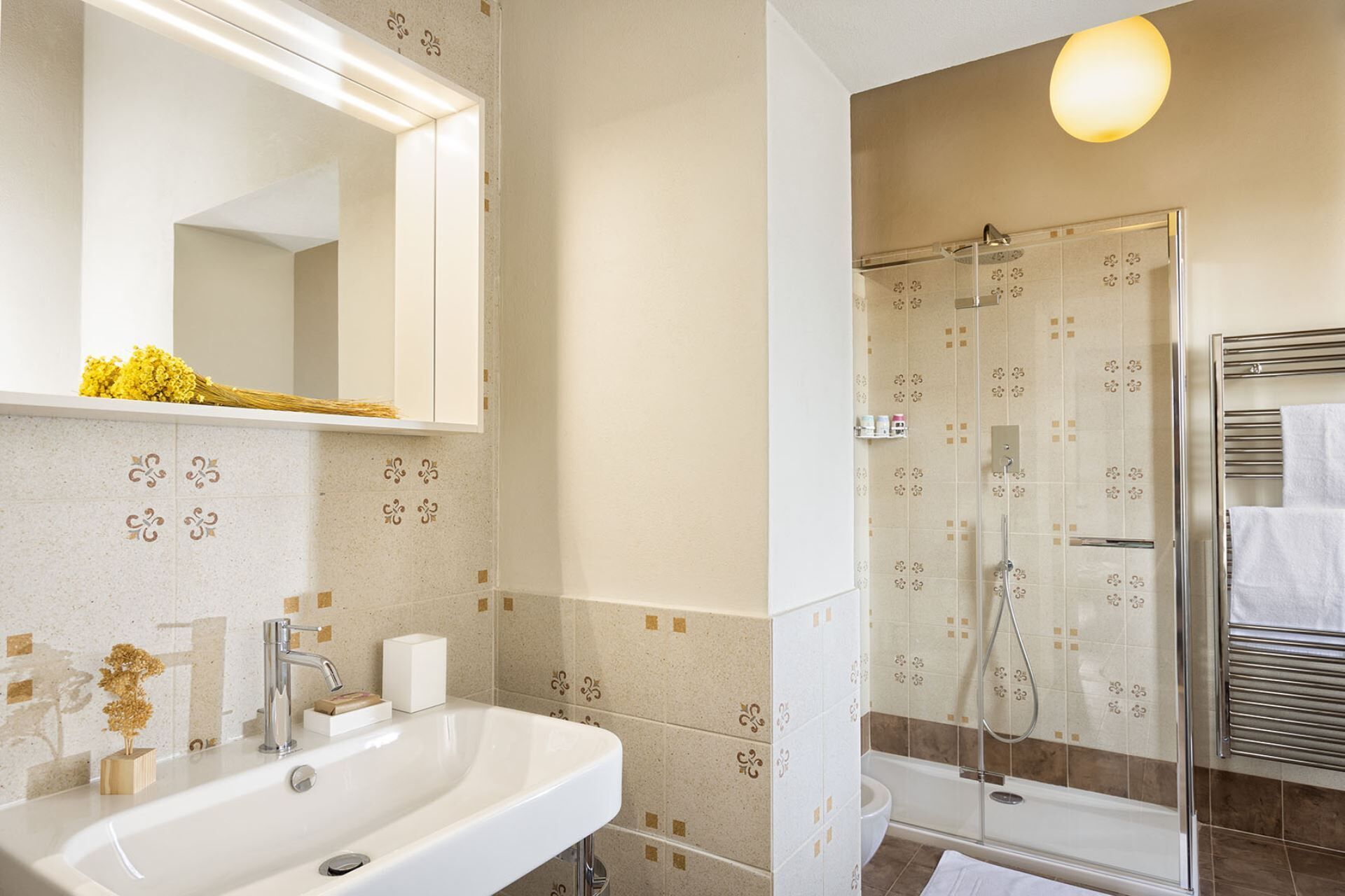 A bathroom with a sink, mirror, and shower.