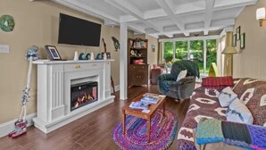 Una sala de estar con chimenea, televisor, sofá y mesa de centro.
