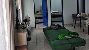 Une pièce comprenant un lit, un bureau, une chaise, une table et un miroir.