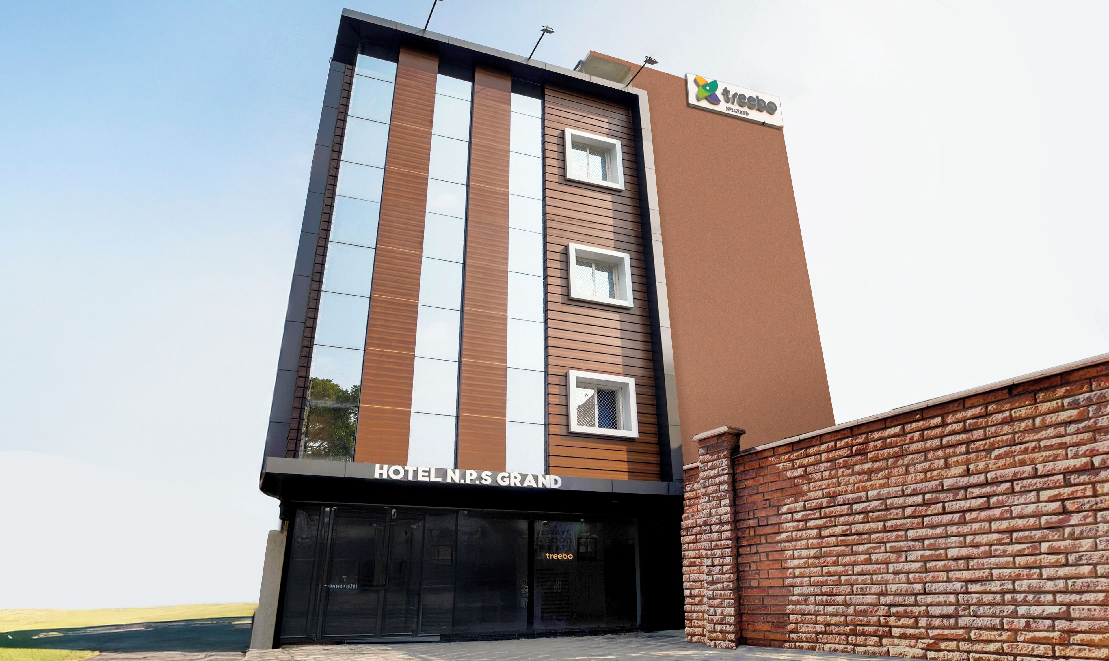 Un moderno edificio de hotel con un cartel que dice "HOTEL N.P.S GRAND".