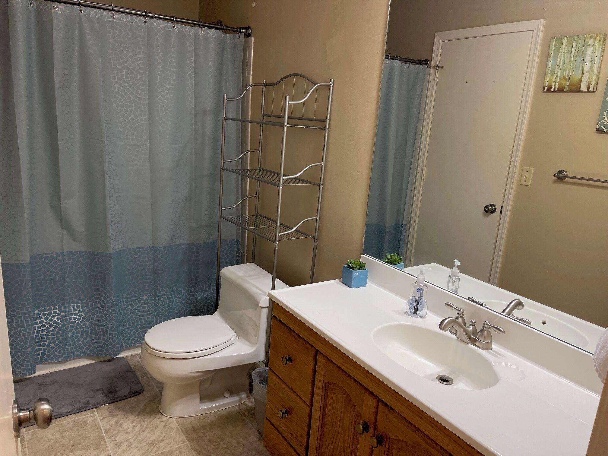 A bathroom with a toilet, sink, and shower curtain.