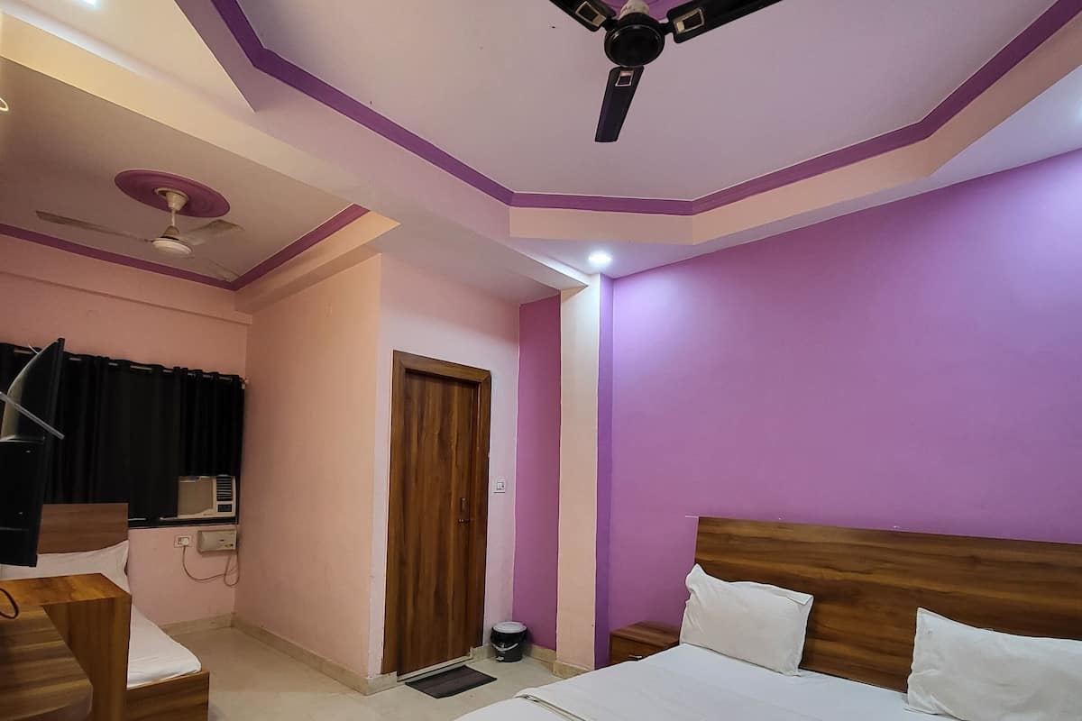 Un dormitorio con cama, escritorio, silla, ventilador de techo y ventana con cortinas.
