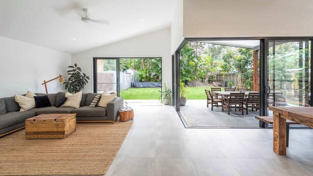 A modern living room with a sofa, coffee table, and a view of the outdoor patio.