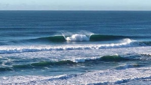 A beach with waves and a clear sky.