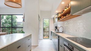 A modern kitchen with a large island, built-in appliances, and a view to the outdoors.