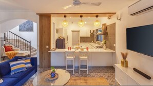 A modern kitchen with a central island, bar stools, pendant lighting, and a ceiling fan. - 4BR Villa With Pool 10 Mins From Calangute Beach (Calangute)