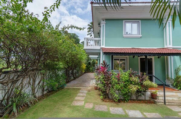 A house with a green exterior, a tiled roof, and a front porch with potted plants. - 4BR Villa With Pool 10 Mins From Calangute Beach (Calangute)