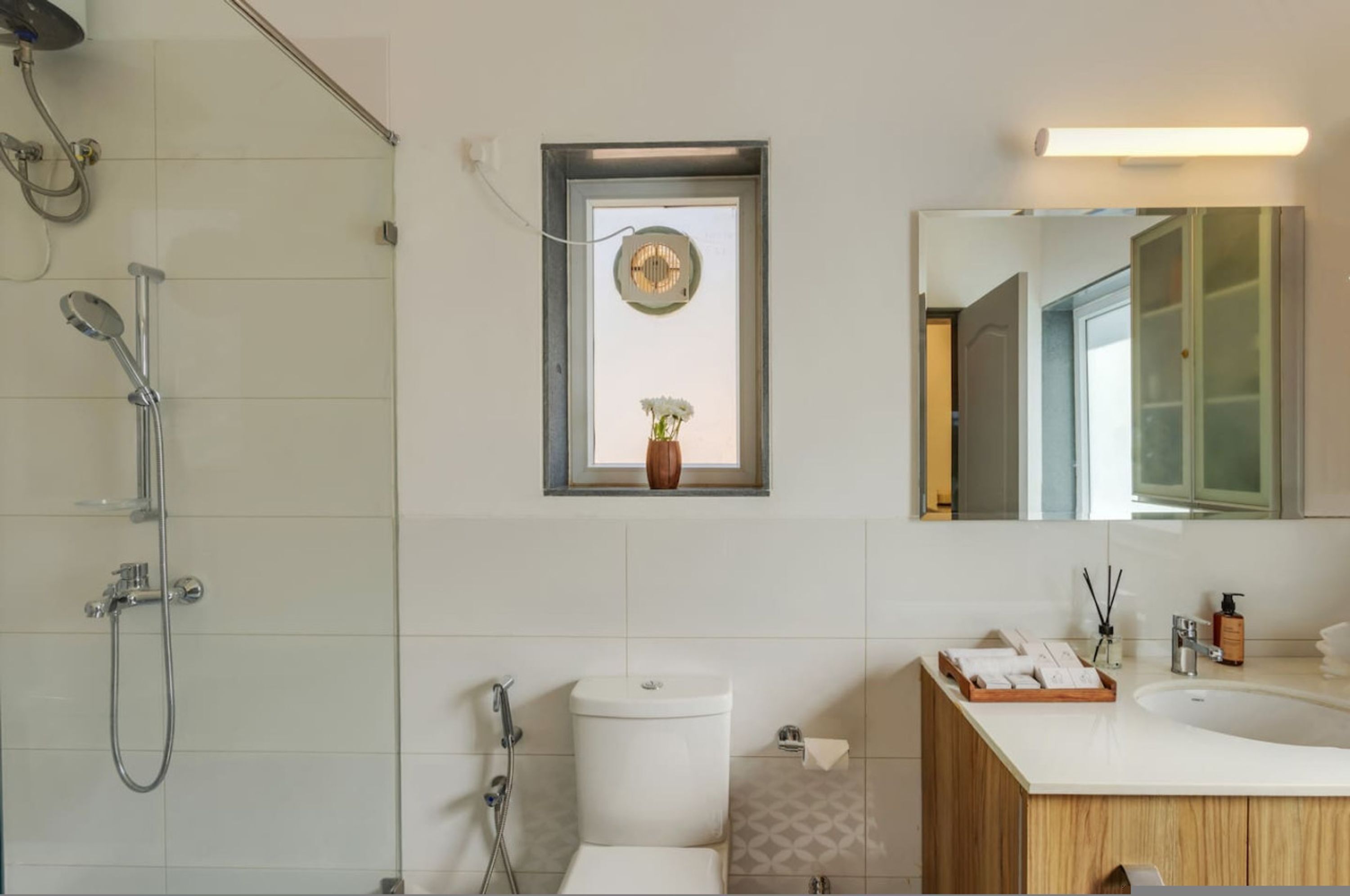 Une salle de bain moderne équipée d’une douche, de toilettes, d’un lavabo et d’un miroir.