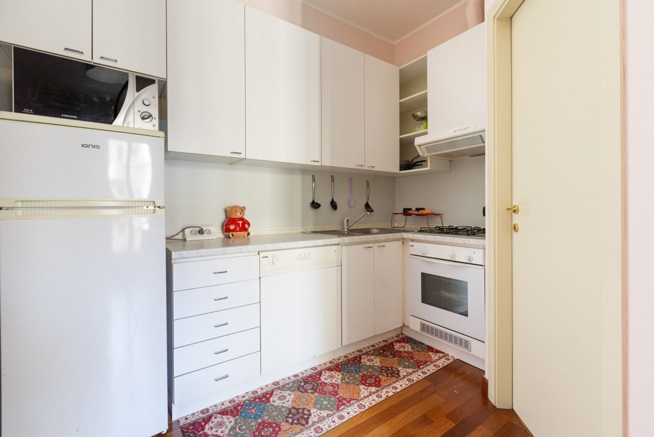 A kitchen with white cabinets, a microwave, a stove, and a dishwasher.