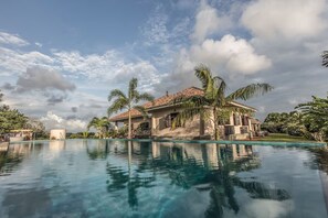 Une grande piscine avec une maison en arrière-plan.