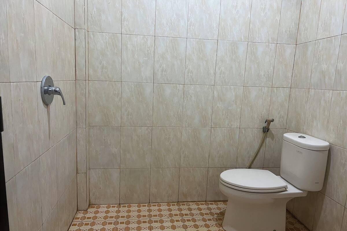 A bathroom with a toilet, a shower, and a sink.