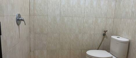 A bathroom with a toilet, a shower, and a sink.