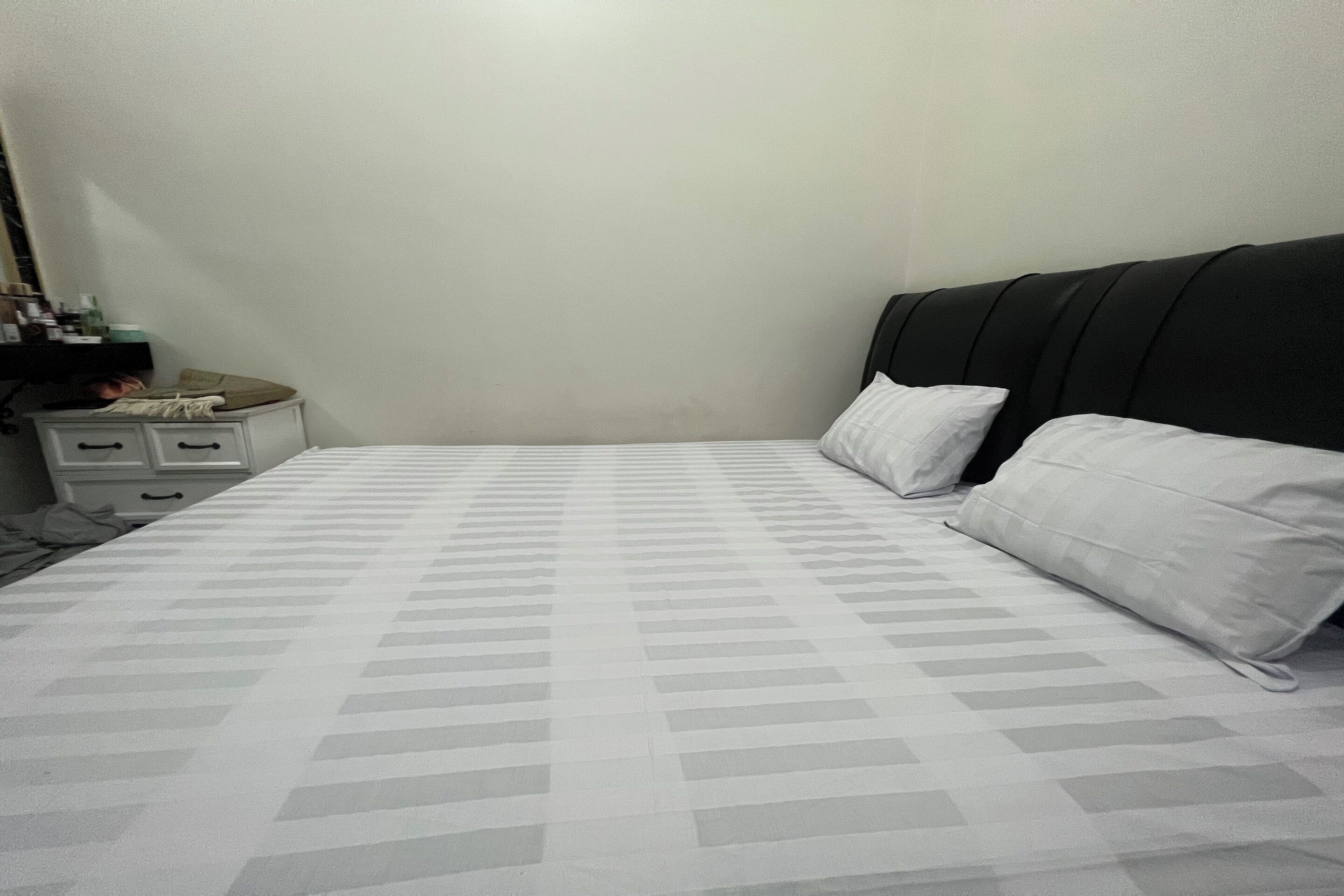 A bedroom with a bed, a nightstand, and a dresser.
