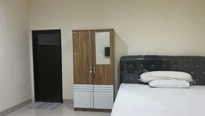 Ein Zimmer mit einem Bett, einem Kleiderschrank und einer Tür.