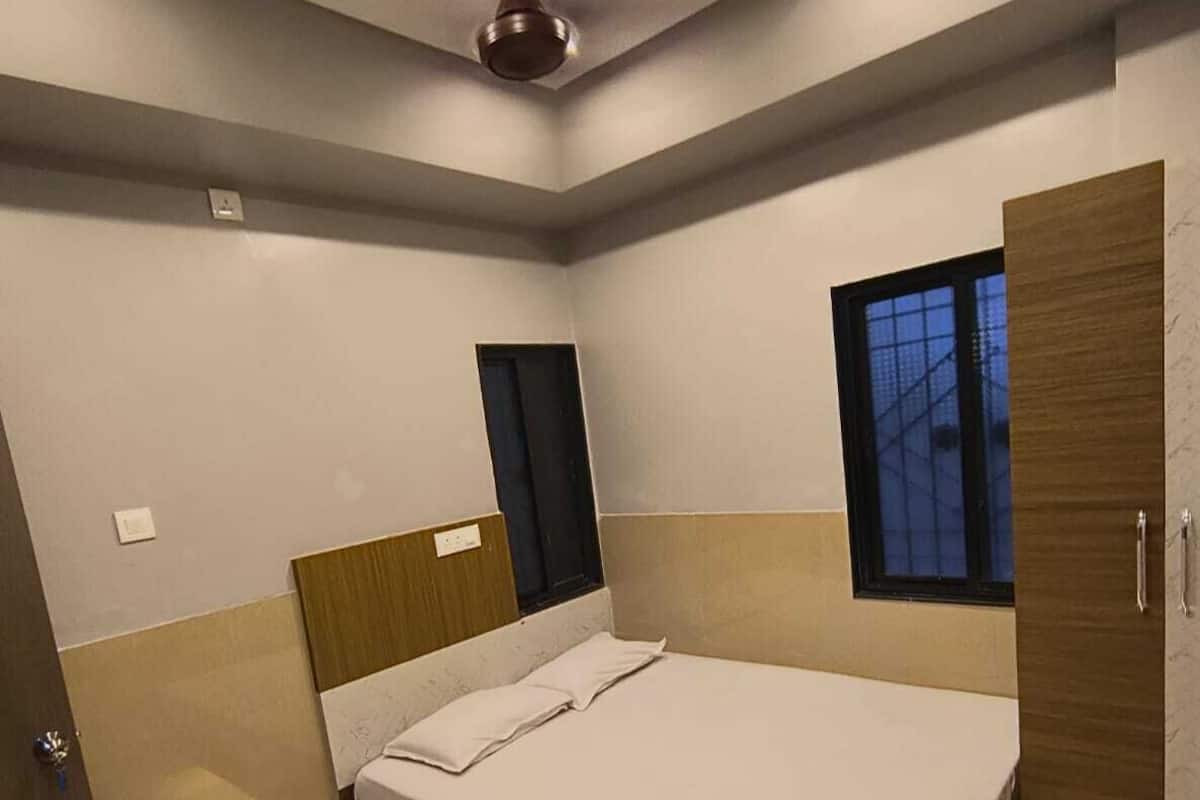 Une chambre à coucher moderne avec un lit, une fenêtre et un ventilateur de plafond.