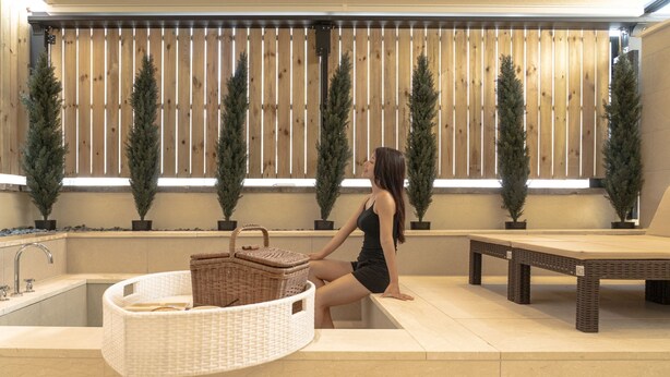 A spa area with a large bathtub, a wicker basket, and a wooden bench. - H-AVENUE Hotel Gwangju Cheomdan (Gwangju)